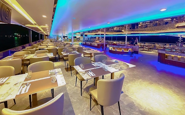 Elegant dining area on the Royal Galaxy Cruise with set tables and ambient lighting.