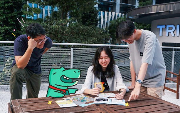 Friends solving puzzles from “The Somerville Adventure” kit at an outdoor table.