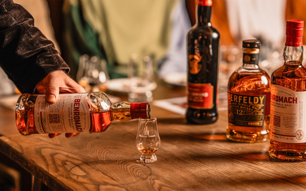 Pouring whiskey into a glass at Megget's Cellar tasting event.