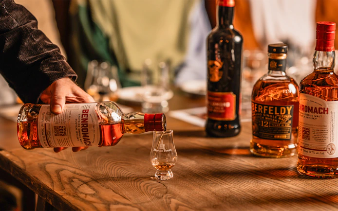 Pouring whiskey into a glass at Megget's Cellar tasting event.