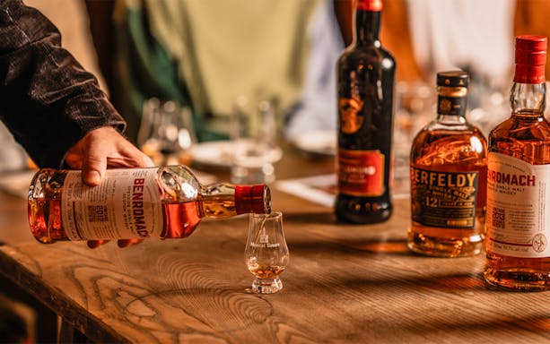 Pouring whiskey into a glass at Megget's Cellar tasting event.