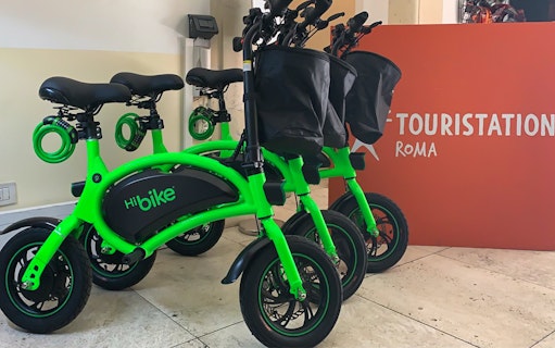 Green e-bikes at a rental station in Rome, Italy, for Baths of Caracalla tour.