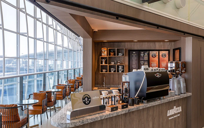 Plaza Premium Lounge coffee bar with Lavazza machine and seating area.