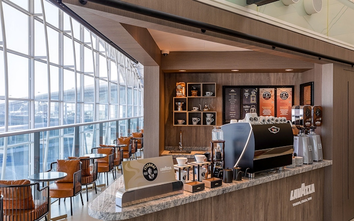 Plaza Premium Lounge coffee bar with Lavazza machine and seating area.