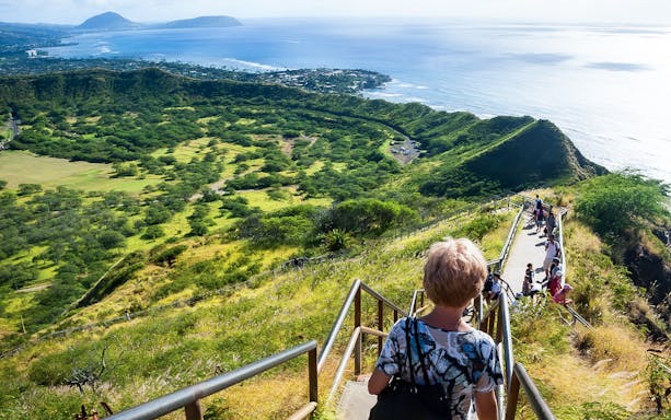 Hikers descending Diamond Head trail with views of Oahu coastline, Hawaii.
