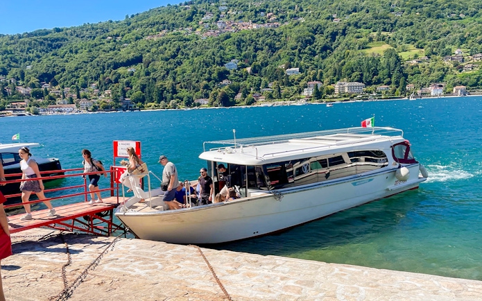 Tourists boarding a boat for the Hop-on Hop-off Isole Borromee tour on Lake Maggiore, Italy.