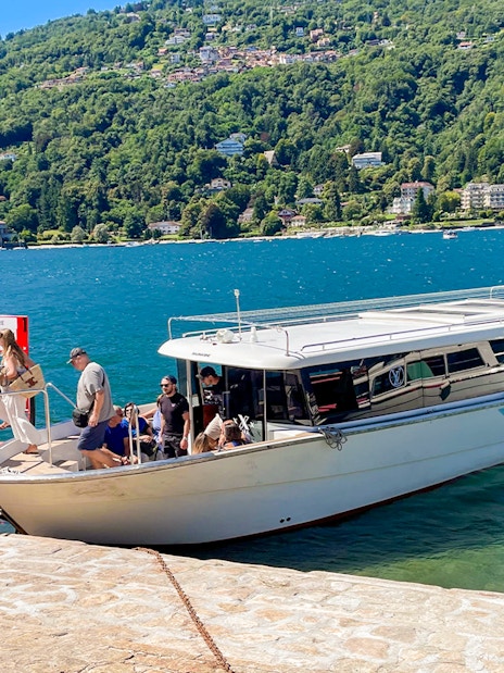 Tourists boarding a boat for the Hop-on Hop-off Isole Borromee tour on Lake Maggiore, Italy.
