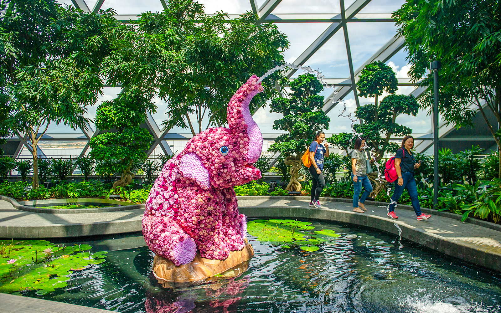 Topiary elephant sculpture in Canopy Park, Jewel Changi, with visitors walking nearby.