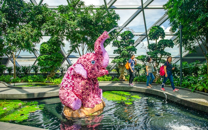 Topiary elephant sculpture in Canopy Park, Jewel Changi, with visitors walking nearby.