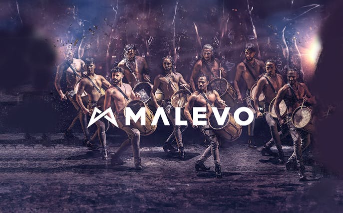 Malevo performers with drums in dynamic dance formation.