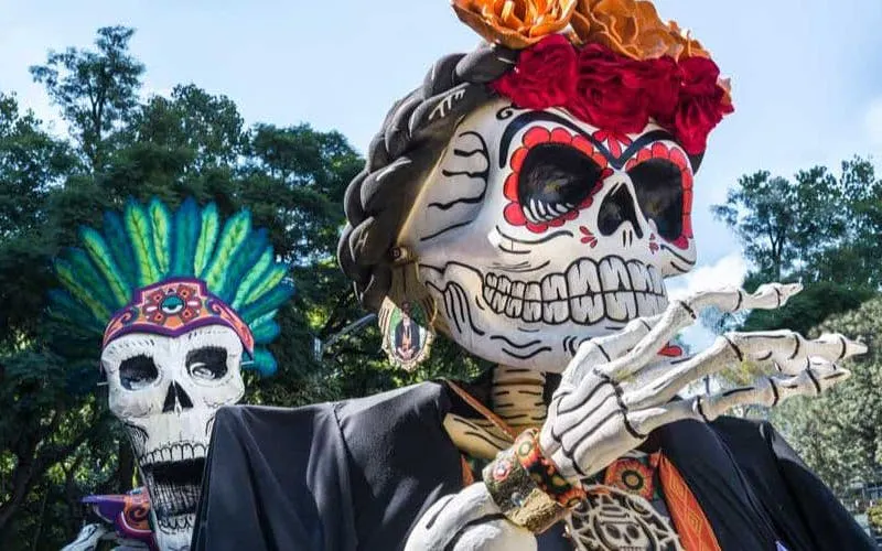 Mixquic Day of the Dead celebration with large decorated skeleton figures.