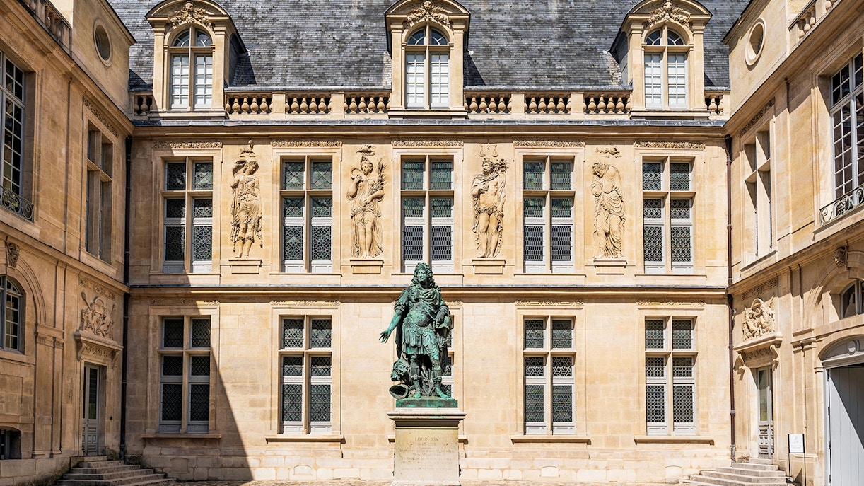 Courtyard of Carnavalet Museum in Paris with historic statue and ornate architecture.