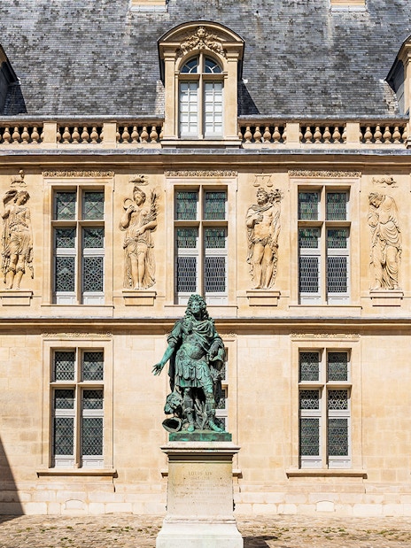Courtyard of Carnavalet Museum in Paris with historic statue and ornate architecture.