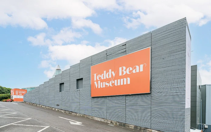 Teddy Bear Museum entrance with large orange sign on modern building.