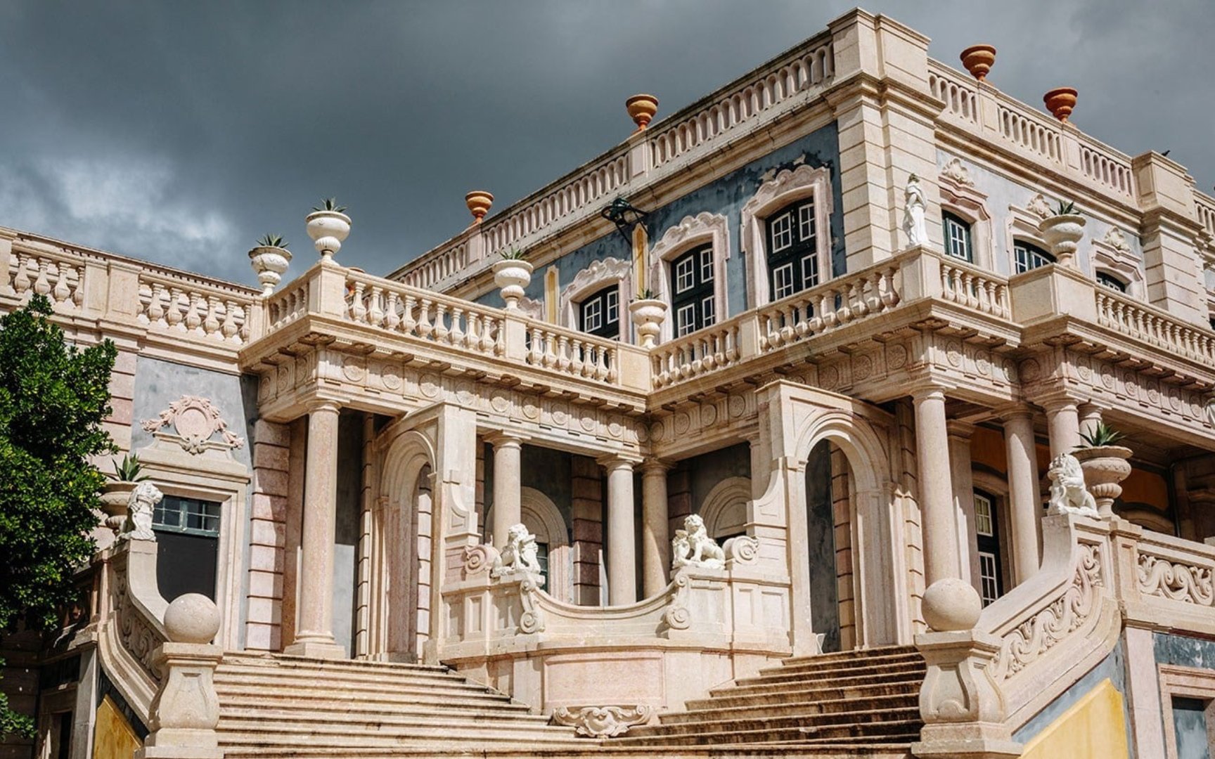 National Palace of Queluz facade with ornate columns and statues, Portugal.
