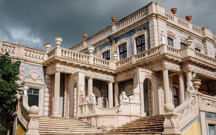 National Palace of Queluz facade with ornate columns and statues, Portugal.