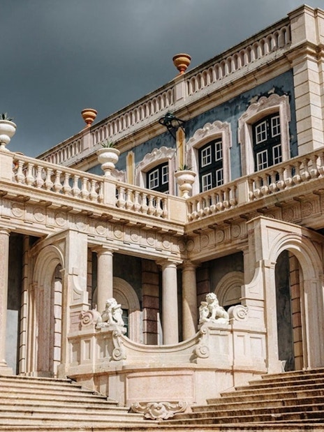 National Palace of Queluz facade with ornate columns and statues, Portugal.