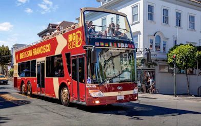 San Francisco hop-on hop-off tour bus driving through city streets.