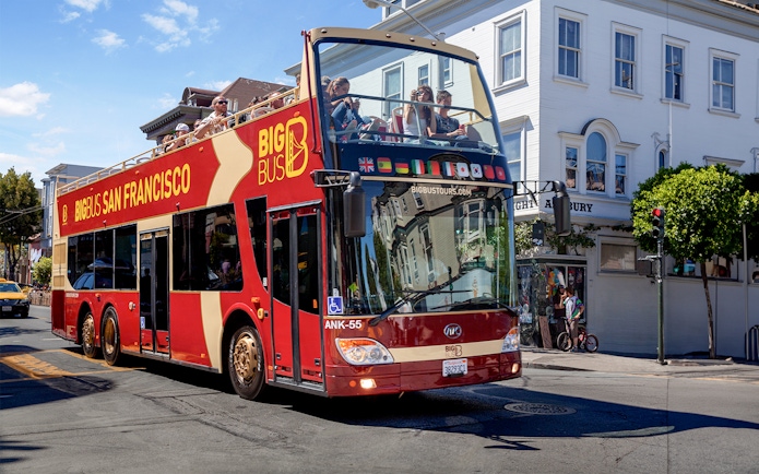 San Francisco hop-on hop-off tour bus driving through city streets.