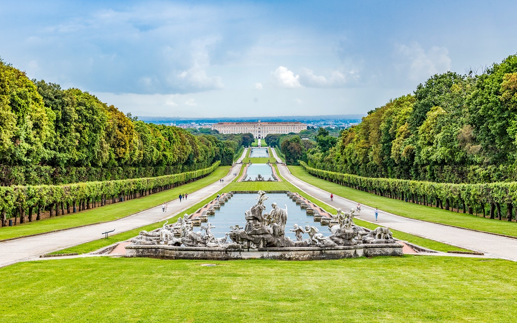 Royal Palace of Caserta gardens with fountains, Campania, Italy, viewed from a distance.