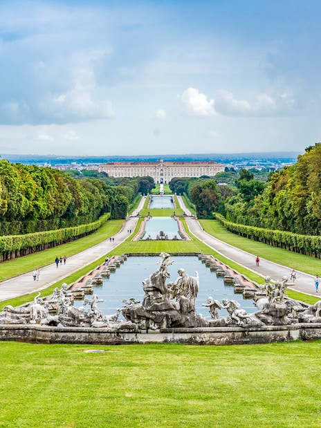 Royal Palace of Caserta gardens with fountains, Campania, Italy, viewed from a distance.