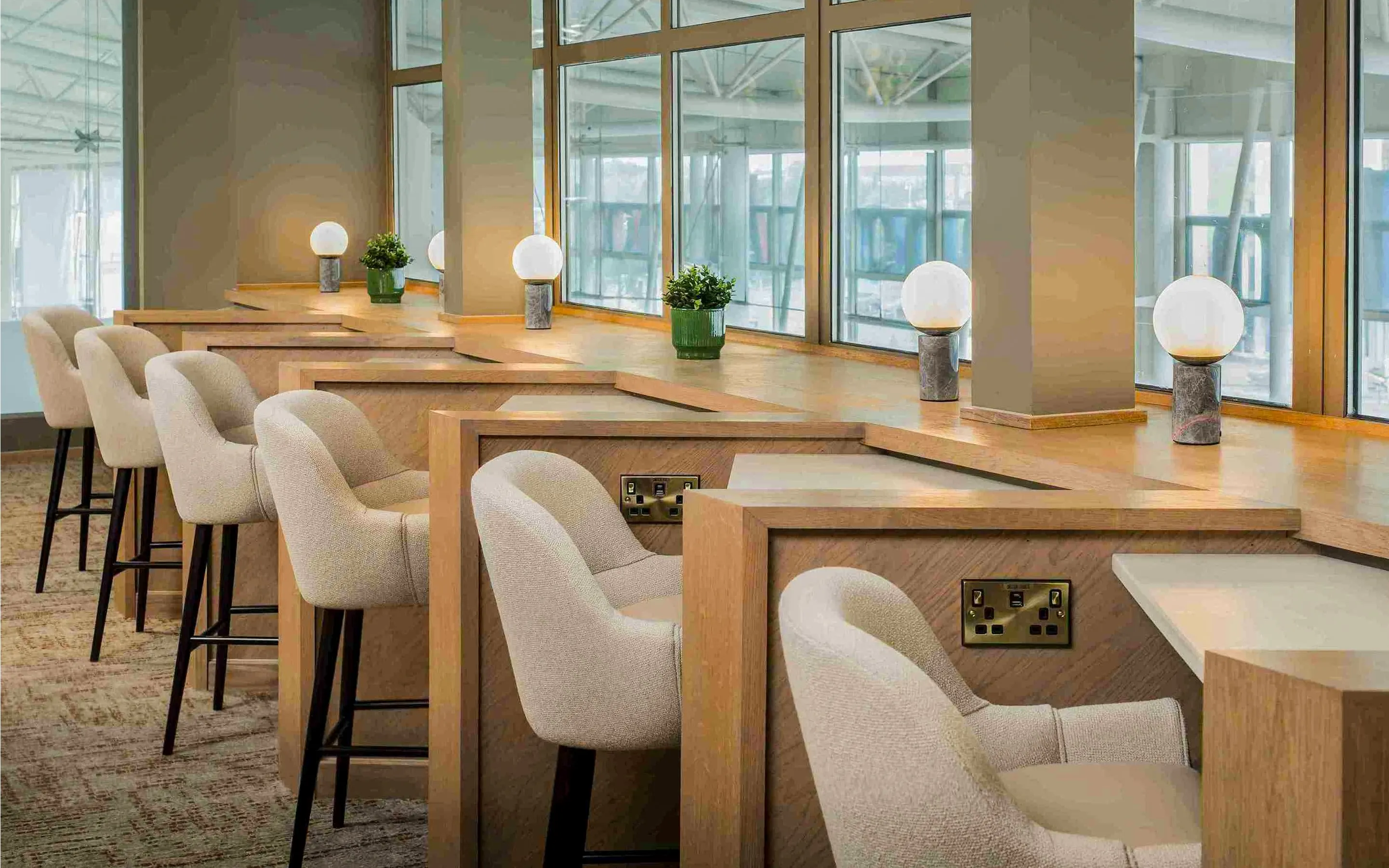 Aspire Lounge seating area with workstations at John Lennon Airport.