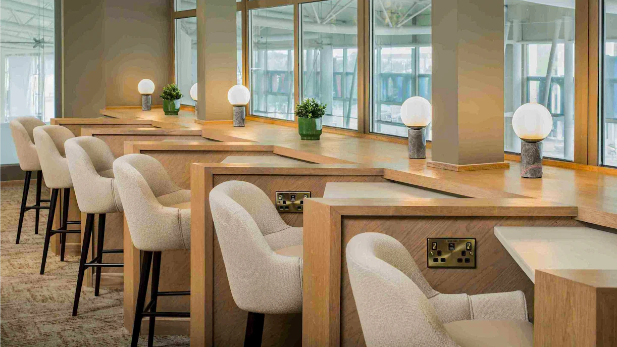 Aspire Lounge seating area with workstations at John Lennon Airport.