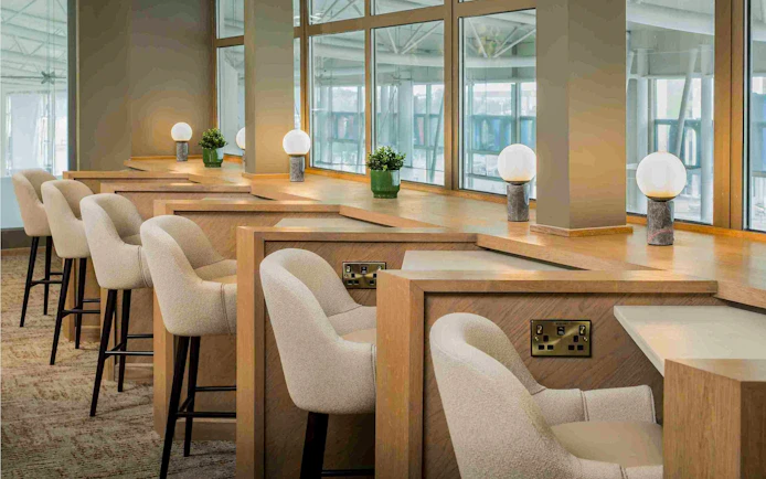 Aspire Lounge seating area with workstations at John Lennon Airport.