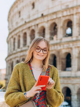 Woman using phone in front of the Colosseum, Rome.