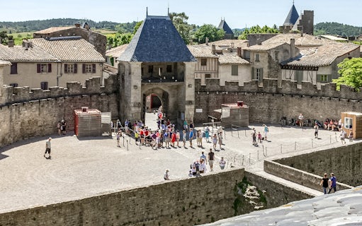 Visitors exploring the courtyard of Comtal Castle in Cité de Carcassonne, France.