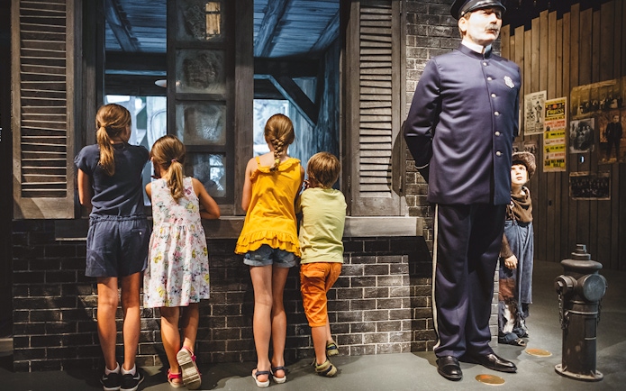 Children observing a display at Chaplin’s World during Lake Geneva tour.