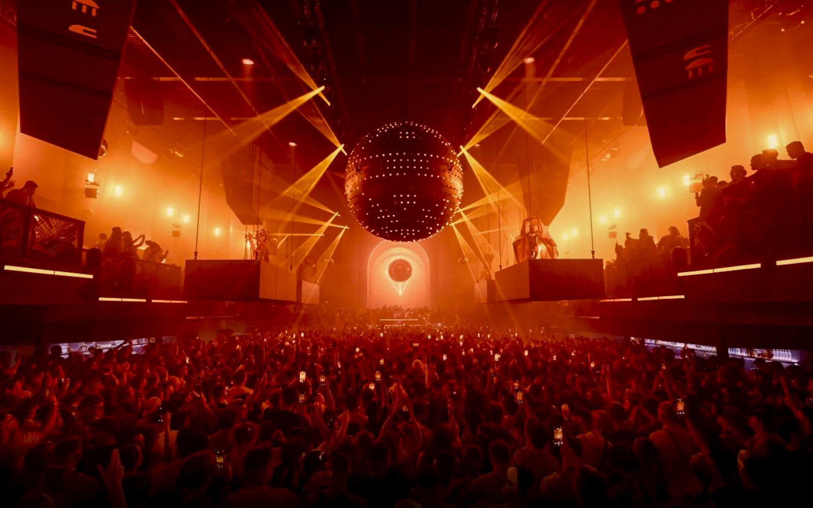 Crowd enjoying a vibrant light show at a nightclub in Ibiza.