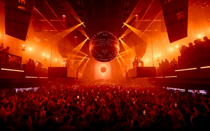 Crowd enjoying a vibrant light show at a nightclub in Ibiza.