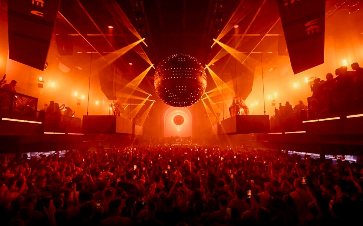 Crowd enjoying a vibrant light show at a nightclub in Ibiza.