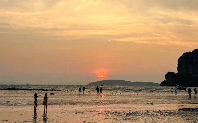 Sunset over Railay Beach with silhouettes of people on the shore, Krabi.
