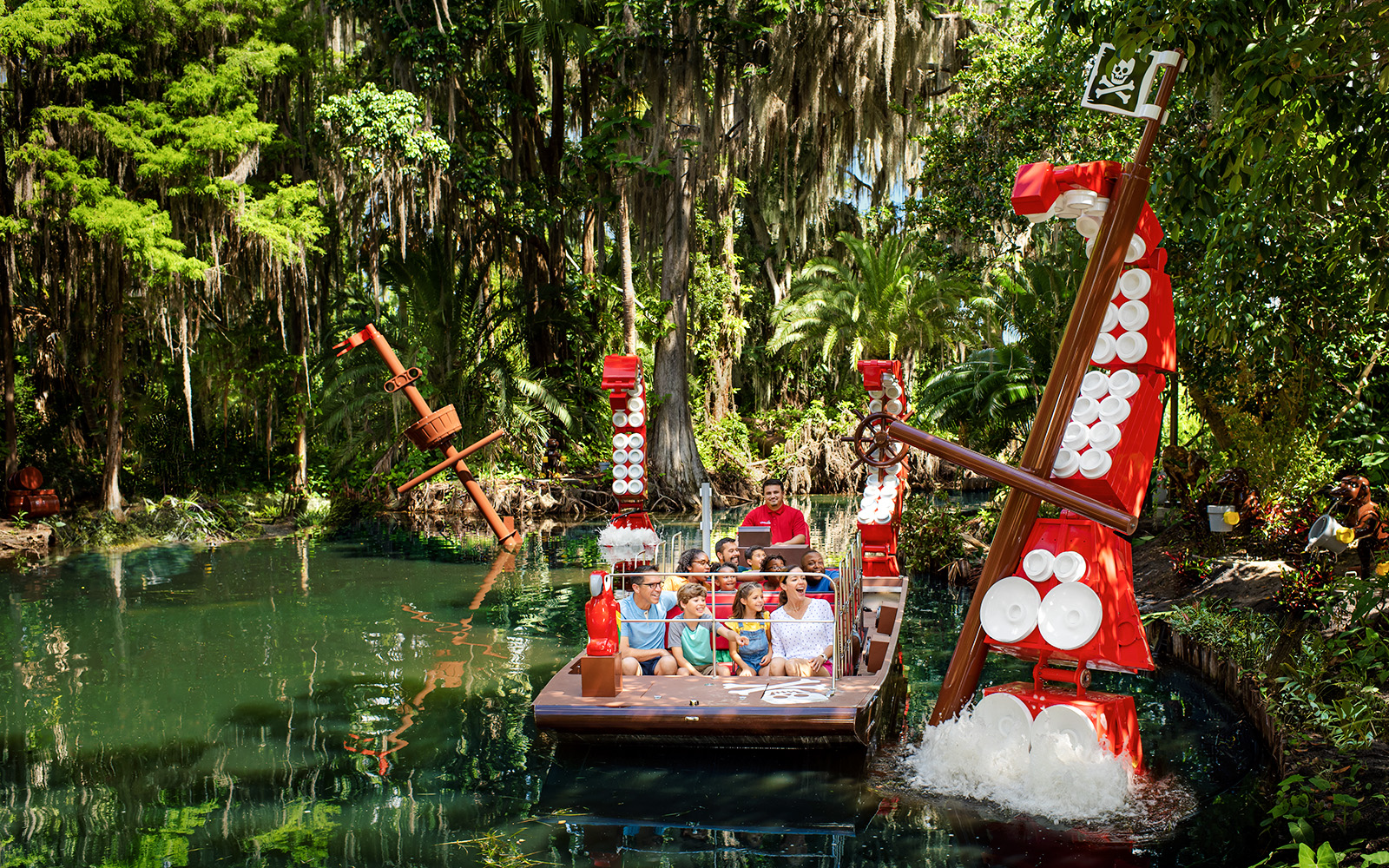 Pirate-themed boat ride through lush greenery at Pirate River Quest, Legoland Florida.
