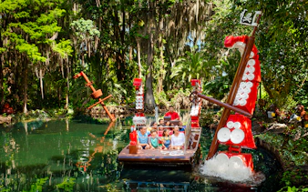 Pirate-themed boat ride through lush greenery at Pirate River Quest, Legoland Florida.