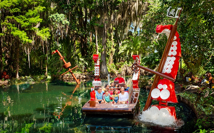 Pirate-themed boat ride through lush greenery at Pirate River Quest, Legoland Florida.