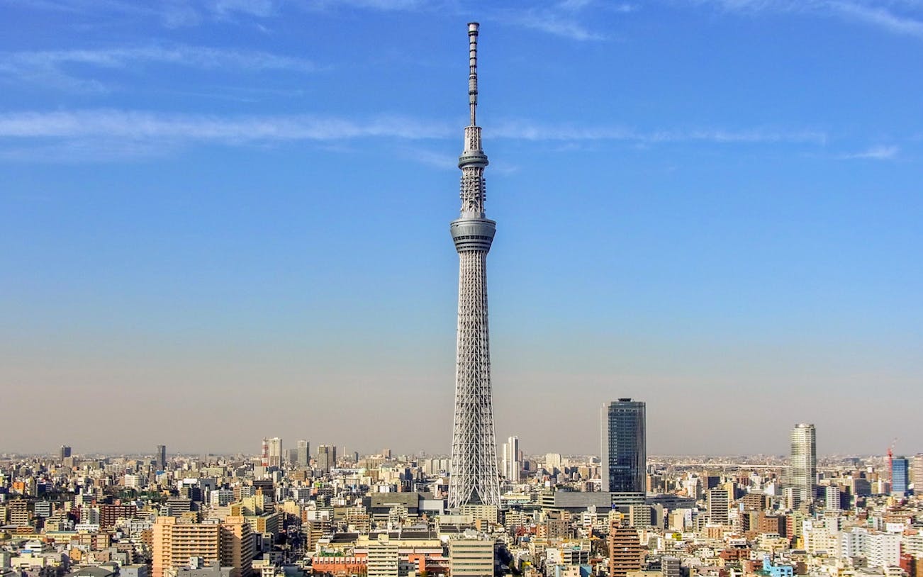 Tokyo Sky Tree towering over the city skyline under a clear blue sky.
