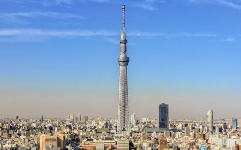 Tokyo Sky Tree towering over the city skyline under a clear blue sky.