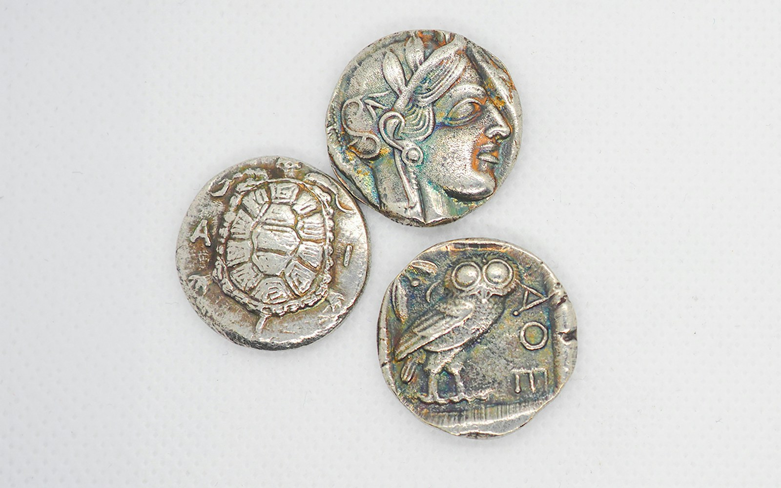 Ancient Athenian silver coins featuring Athena, an owl, and a turtle.