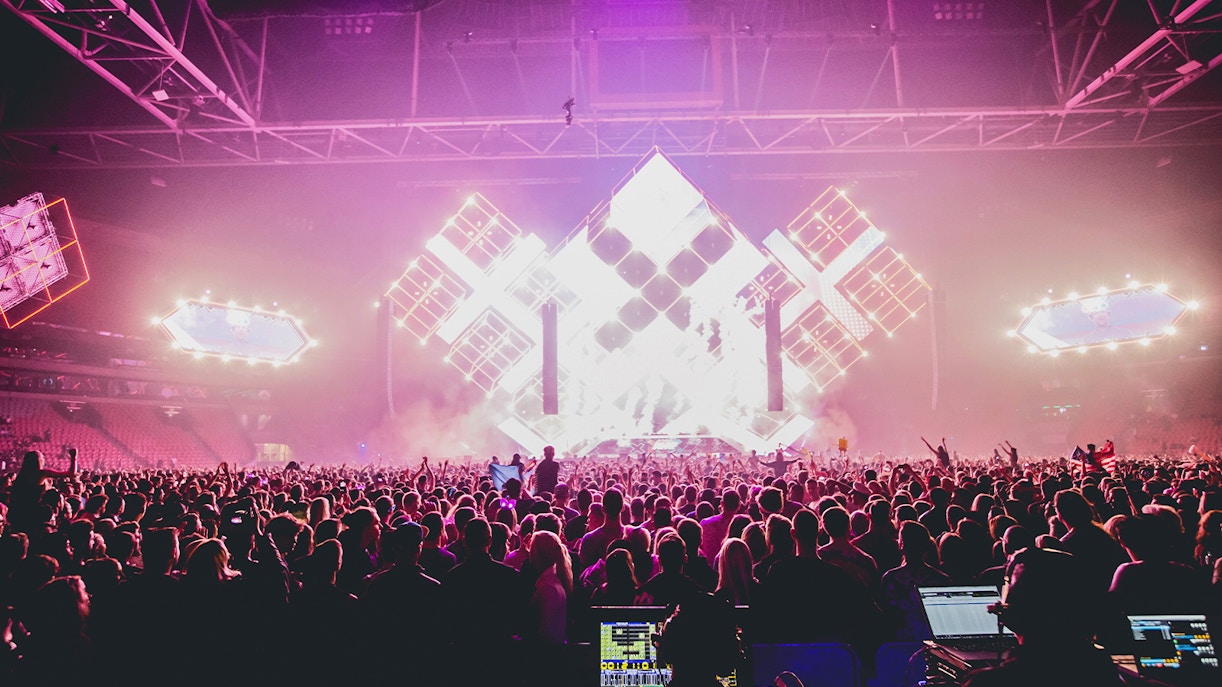 People dancing at Amsterdam Dance Event ADE with vibrant lights in the background.