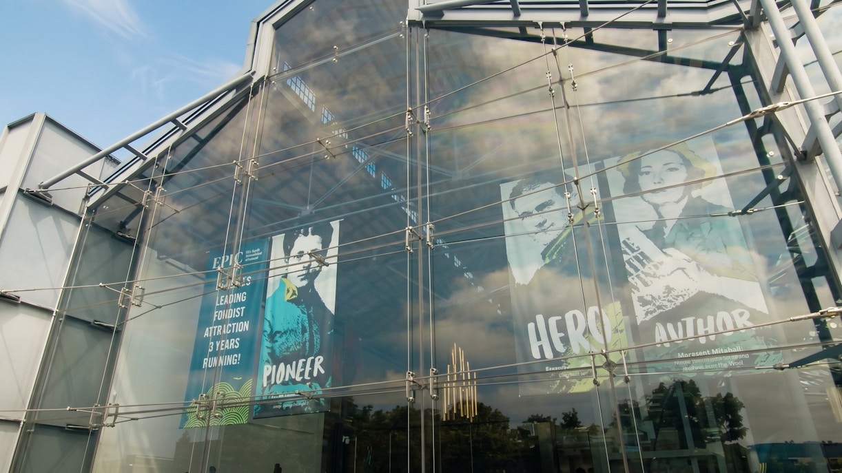 Glass facade of EPIC Museum with posters of historical figures.