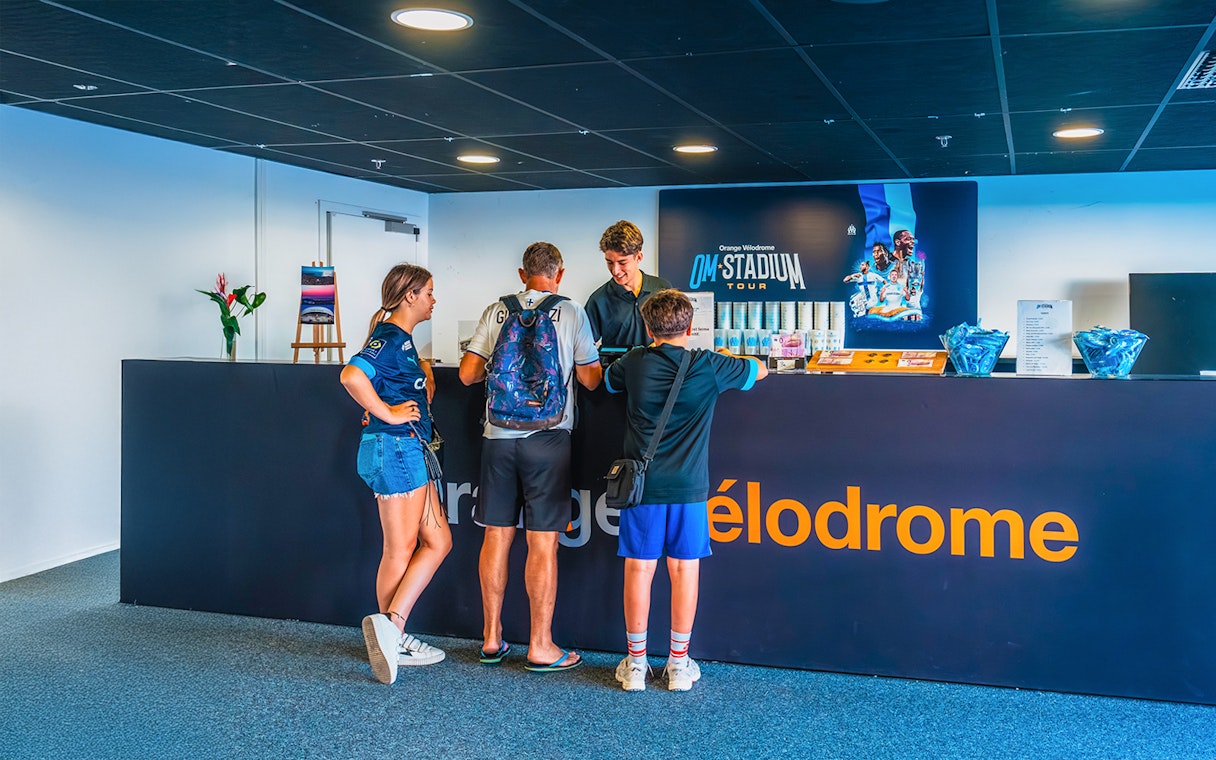 Visitors at reception desk for OM Stadium Tour at Orange Vélodrome.