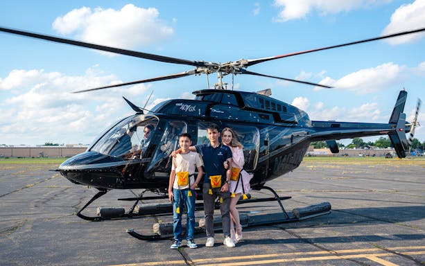 Helicopter on tarmac with passengers ready for New York tour.