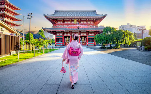 Asian woman in kimono walking towards Sensoji Temple in Tokyo, Japan.