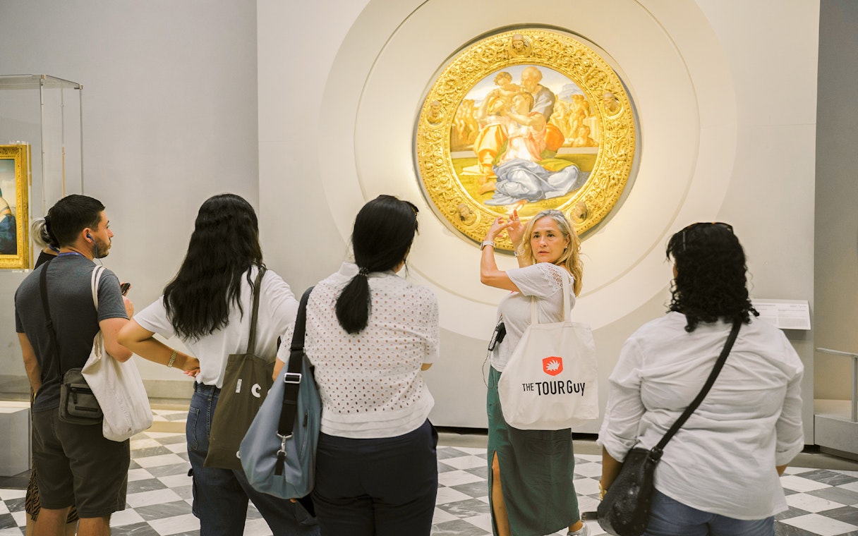 Guide explaining artwork to visitors in a gallery.