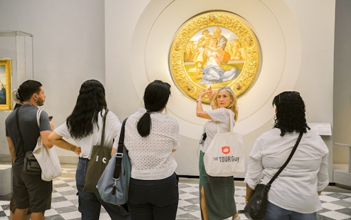 Guide explaining artwork to visitors in a gallery.