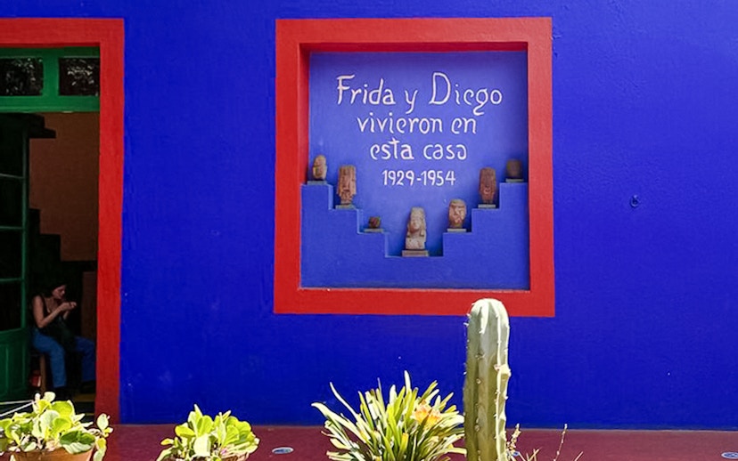 Frida Kahlo Museum blue wall with red-framed niche and sculptures, Coyoacán, Mexico City.