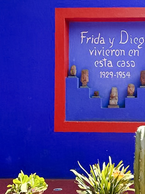 Frida Kahlo Museum blue wall with red-framed niche and sculptures, Coyoacán, Mexico City.